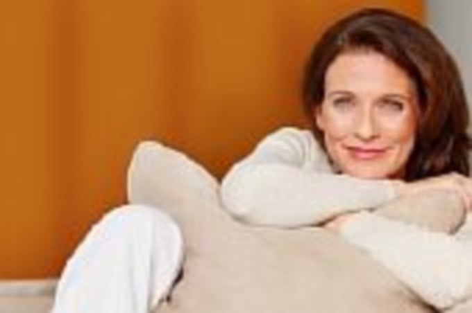 Женщина среднего возраста улыбающаяся женщина с подушкой